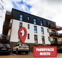 Na predaj krásny apartmám v Štrbe - Bytový dom na Lúčnej ulici v Štrbe s vyznačeným parkovacím miestom v popredí.