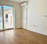 REZERVOVANÉ Na prenájom 4 izbový rodinný dom, Pata, ul. Pod Vinohradmi - Izba s klimatizáciou a veľkým oknom, podlaha s dreveným dekorom v rodinnom dome.