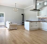 REZERVOVANÉ Na prenájom 4 izbový rodinný dom, Pata, ul. Pod Vinohradmi - Obývacia izba s kuchyňou v rodinnom dome, s podlahou s dreveným dekorom a krbom.