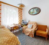 Na predaj rod. dom v obci Radošovce - Vieska, okr. Skalica. - Izba v rodinnom dome s posteľou, kobercom, kreslom a obrazom na stene.