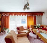 Na predaj rod. dom v obci Radošovce - Vieska, okr. Skalica. - Obývacia izba v rodinnom dome s oranžovými závesmi a štýlovým zariadením.