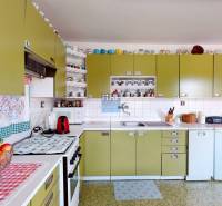 Na predaj rod. dom v obci Radošovce - Vieska, okr. Skalica. - Kuchyňa v rodinnom dome s olivovými skrinkami, spotrebičmi a poličkami so šálkami.