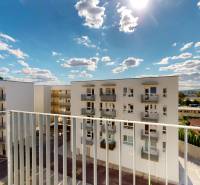 Nájom garsónka, 34 m2 | kryté parkovanie | Odevná, Trenčín - Výhľad z garsónky na ulici Odevná v Trenčíne, zobrazuje bytové domy a oblohu.