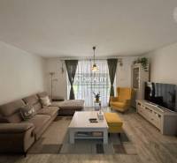 REZERVOVANÉ - Predaj, rodinný dom Malinová - NOVOSTA... - Obývačka v rodinnom dome so sedačkou, kreslom, televízorom a kvetmi.