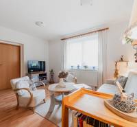 VÝBORNÁ CENA  3 izbový byt Armádna ulica v Trenčíne  - Obývačka 3-izbového bytu s pohodlným nábytkom a podlahou s dreveným dekorom.