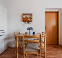 VÝBORNÁ CENA  3 izbový byt Armádna ulica v Trenčíne  - Jedálenský stôl so stoličkami, chladnička a podlaha s dreveným dekorom v 3-izbovom byte.