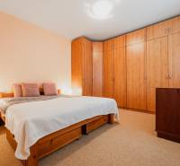 VÝBORNÁ CENA  3 izbový byt Armádna ulica v Trenčíne  - Spálňa v 3-izbovom byte s posteľou, vstavanou skriňou a podlahou s dreveným dekorom.