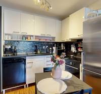 3D, predaj 3 izb. byt, balkón, loggia, klíma, Agátová ul., Dúbravka - Kuchyňa v 3-izbovom byte s bielymi skrinkami, čiernymi spotrebičmi a jedálenským stolom.