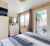 3D, predaj 3 izb. byt, balkón, loggia, klíma, Agátová ul., Dúbravka - Spálňa v 3-izbovom byte s televízorom, komodou, oknami a kvetmi, svetlé a útulné prostredie.