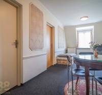 Predaj nehnuteľnosti v mestskej časti Poprad-Veľká - Interiér hotela a penziónu s okrúhlym stolom, koberec, TV a ozdobné steny.