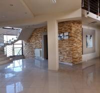 EXKLUZÍVNA VILA - NITRA - PREDAJ - Interiér rodinného domu s keramickou dlažbou, kamenným obkladom a moderným schodiskom.