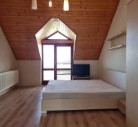 EXKLUZÍVNA VILA - NITRA - PREDAJ - Podkrovná izba v rodinnom dome s drevenými stropmi a posteľou.