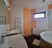 EXKLUZÍVNA VILA - NITRA - PREDAJ - Kúpeľňa v rodinnom dome so sprchou, vaňou a zrkadlom, svetlé dlaždice a okno.