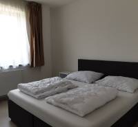 PRENÁJOM - Byt s krásnym výhľadom - Nitra, Dolnohorská - Spálňa v 2-izbovom byte s jednoduchou posteľou a svetlými závesmi.
