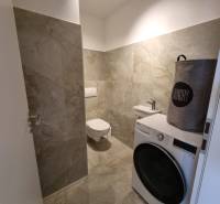 PRENÁJOM - 3 izbový byt Nitra – RIVIERA NITRA, Piesková ulica - Kúpeľňa so sivými dlaždicami, práčkou a košom na prádlo v 3-izbovom byte.