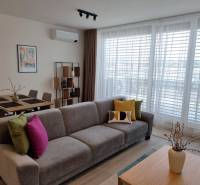 PRENÁJOM - 3 izbový byt Nitra – RIVIERA NITRA, Piesková ulica - Obývacia izba s pohovkou, jedálenským stolom a policami v 3-izbovom byte.