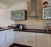 PREDAJ - Exkluzívny rodinný dom - Nitra, Zobor - Kuchyňa v rodinnom dome s bielymi skrinkami, kuchynskými spotrebičmi a mozaikovým obkladom.