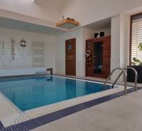 PREDAJ - Exkluzívny rodinný dom - Nitra, Zobor - Rodinný dom s vnútorným bazénom, saunou a dekoratívnou výzdobou, drevený dekor na stenách.