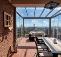 PREDAJ - Exkluzívny rodinný dom - Nitra, Zobor - Zasklená terasa rodinného domu s tehlovým múrom a panoramatickým výhľadom na Nitru.