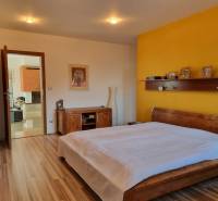 PREDAJ - Exkluzívny rodinný dom - Nitra, Zobor - Spálňa s posteľou, žltou stenou a podlahou s dreveným dekorom v rodinnom dome.