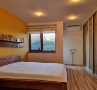 PREDAJ - Exkluzívny rodinný dom - Nitra, Zobor - Spálňa v rodinnom dome s manželskou posteľou, žltou stenou a podlahou s dreveným dekorom.