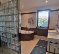 PREDAJ - Exkluzívny rodinný dom - Nitra, Zobor - Kúpeľňa v rodinnom dome s rohovou vaňou, sklobetónovou stenou a dvomi umývadlami.