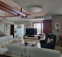 PREDAJ - Exkluzívny rodinný dom - Nitra, Zobor - Interiér obývačky rodinného domu s bielou sedačkou, televízorom a schodmi.