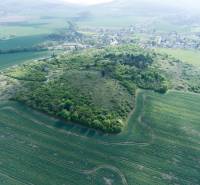 PREDAJ - Pozemok s krásnymi výhľadmi v lesnom prostredí - Podhorany - Letecký pohľad na zelené pozemky a okolitú krajinu využívanú na bývanie.
