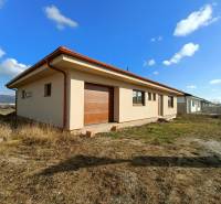 PREDAJ - 4 izbový holodom s veľkou garážou , Lužianky, Smreková ulica - Jednopodlažný rodinný dom s červenou strechou, obklopený prírodou a trávnatými plochami.