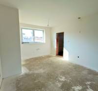 PREDAJ - 4 izbový holodom s veľkou garážou , Lužianky, Smreková ulica - Prázdna miestnosť s veľkým oknom, pripravená na dokončenie v rodinnom dome.