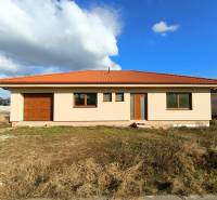 PREDAJ - 4 izbový holodom s veľkou garážou , Lužianky, Smreková ulica - Rodinný dom s červenou škridlovou strechou na trávnatom pozemku pod modrou oblohou.