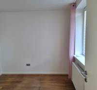 PREDAJ - 3 izbový dom v centre mesta, Nitra - Izba v rodinnom dome s podlahou s dreveným dekorom a svetloružovým závesom.