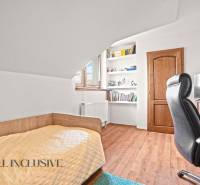 NA PREDAJ 5+2 IZBOVÝ RD PRI KÚPALISKU, DUNAJSKÁ STREDA - Izba v rodinnom dome s posteľou, policami, stolom a podlahou s dreveným dekorom.