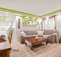 NA PREDAJ 5+2 IZBOVÝ RD PRI KÚPALISKU, DUNAJSKÁ STREDA - Obývačka v Rodinnom dome s podlahou s dreveným dekorom a zelenými detailmi na strope.