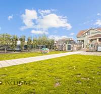 NA PREDAJ 5+2 IZBOVÝ RD PRI KÚPALISKU, DUNAJSKÁ STREDA - Záhrada rodinného domu na Kúpeľnej ulici v Dunajskej Strede s udržiavaným trávnikom a stromami.