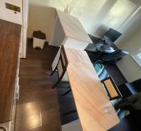 MH279-Na predaj 1 izbový byt v oblúbenej lokalite Komárna! - Kuchyňa v 1-izbovom byte s dreveným dekorom podlahy, barovým pultom a pracovným stolom.