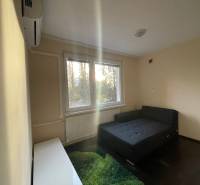 MH279-Na predaj 1 izbový byt v oblúbenej lokalite Komárna! - Jednoduchá izba s posteľou, kobercom a oknom v 1-izbovom byte.
