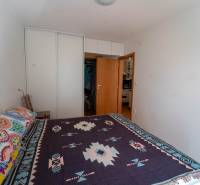 Na predaj útulný 2 izbový byt so zahradkou Svätý Jur 165.000,- Eur - Spálňa v 2-izbovom byte s veľkou posteľou, vstavanou skriňou a farebnými textíliami.