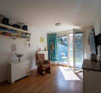 Na predaj útulný 2 izbový byt so zahradkou Svätý Jur 165.000,- Eur - Obývací priestor v 2-izbovom byte s podlahou s dreveným dekorom a prístupom na terasu.