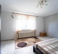 Na predaj rodinný dom s rozľahlým pozemkom 1788m2 MODRA - Svetlá spálňa s televízorom a koberec v rodinnom dome, podlaha s dreveným dekorom.