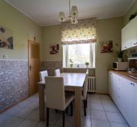 Na predaj rodinný dom s rozľahlým pozemkom 1788m2 MODRA - Kuchyňa v rodinnom dome s dreveným dekorom stola a bielymi skrinkami.