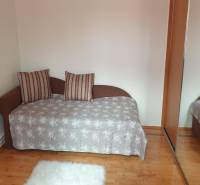 Novinka: Praktický byt v širšom centre. Mestská ul. Províziu neplatíte - Izba v 2-izbovom byte s pohovkou, zrkadlovou skriňou a podlahou s dreveným dekorom.