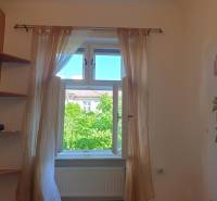 Novinka: Praktický byt v širšom centre. Mestská ul. Províziu neplatíte - Svetlý interiér 2-izbového bytu s dekoratívnymi závesmi a výhľadom na zeleň vonku.