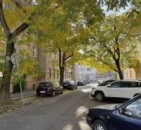 Novinka: Praktický byt v širšom centre. Mestská ul. Províziu neplatíte - Ulica Mestská v Bratislave - Novom Meste, lemovaná stromami a zaparkovanými autami.