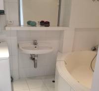 Novinka: Praktický byt v širšom centre. Mestská ul. Províziu neplatíte - Kúpeľňa v 2-izbovom byte s vaňou, umývadlom a práčkou, jednoduchý biely dizajn.