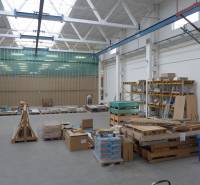 Sklad na prenájom o celkovej ploche 1015 m2 - V sklade sú palety so stavebným materiálom a regály s uloženými doskami.