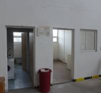 Sklad na prenájom o celkovej ploche 1015 m2 - V skladoch a halách sú dvere, práčka, ventilátor a červený kôš.