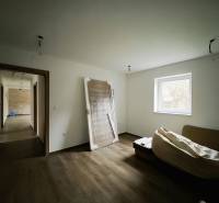 REZERVOVANÉ |Exkluzívne na predaj rodinný dom, Kolárovice (okres Bytča - Miestnosť v rodinnom dome s podlahou s dreveným dekorom a jednoduchým zariadením.