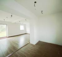 REZERVOVANÉ |Exkluzívne na predaj rodinný dom, Kolárovice (okres Bytča - Interiér rodinného domu s podlahou s dreveným dekorom a veľkými oknami do záhrady.