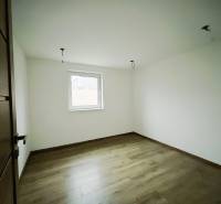 REZERVOVANÉ |Exkluzívne na predaj rodinný dom, Kolárovice (okres Bytča - Izba v rodinnom dome s bielymi stenami a podlahou s dreveným dekorom.